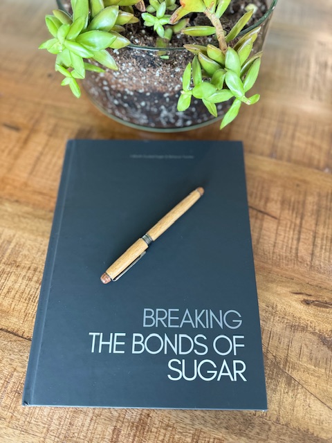 Picture of the front of a black journal with the title Breaking the Bonds of Sugar written in white.